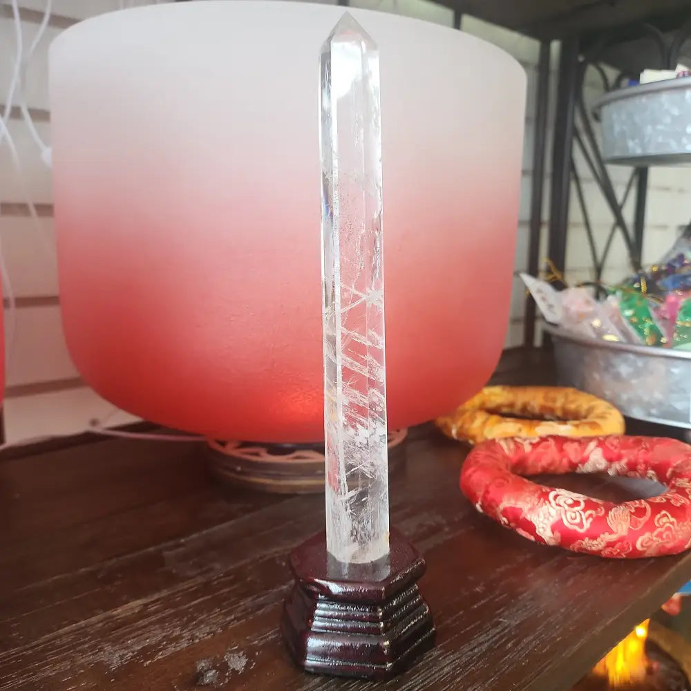 Hand-carved Clear Quartz tower featuring brilliant transparency and natural inclusions, displayed on a white background.