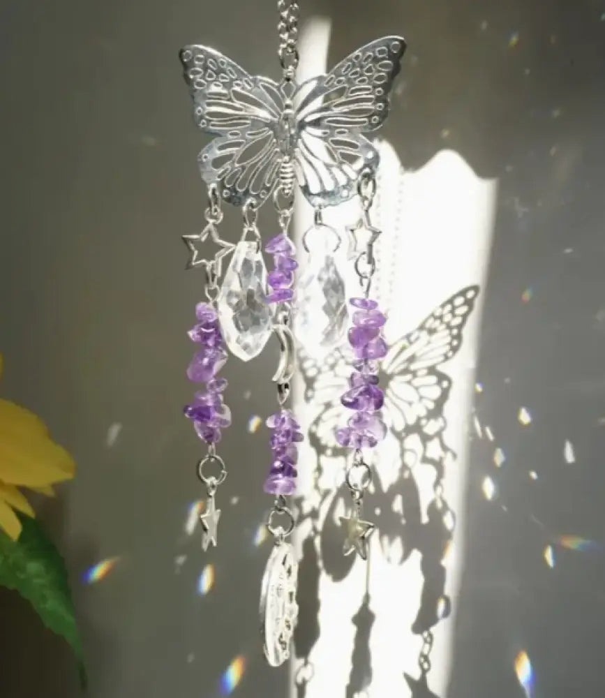 Butterfly-shaped ornament with purple beads and stars on a blurred background