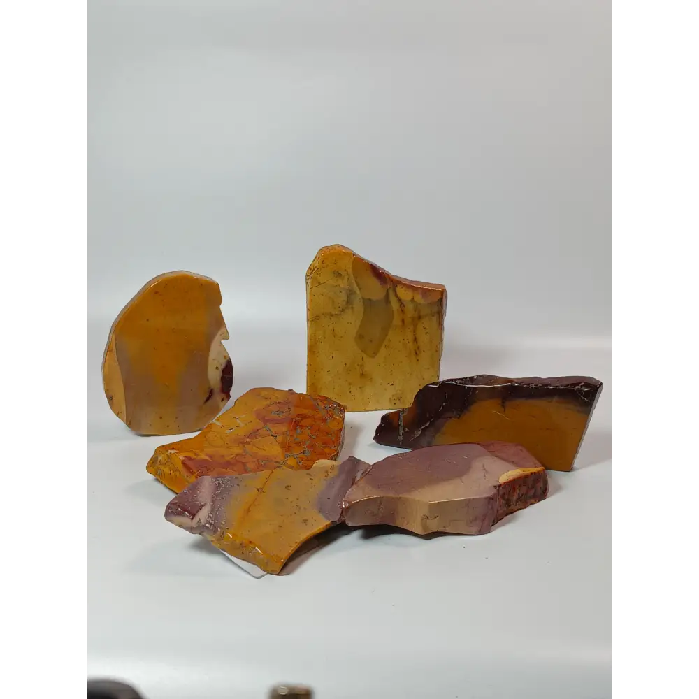 Hand-polished Mookaite slab, 2–2.5 inches, with vibrant red, yellow, and cream patterns, displayed on a white background.