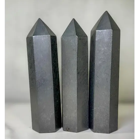 Hand-carved Noble Shungite tower featuring a lustrous, jet-black finish, displayed on a white background.