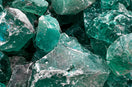 A pile of jagged translucent emerald green glass rocks with sharp edges
