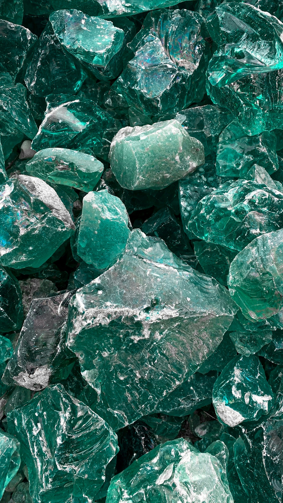 A pile of jagged translucent emerald green glass rocks with sharp edges