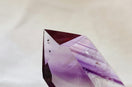 an amethyst shaped piece of glass sitting on a table