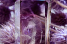 a purple crystal with a figure inside of it