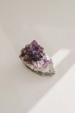 a cluster of purple crystals sitting on top of a white table