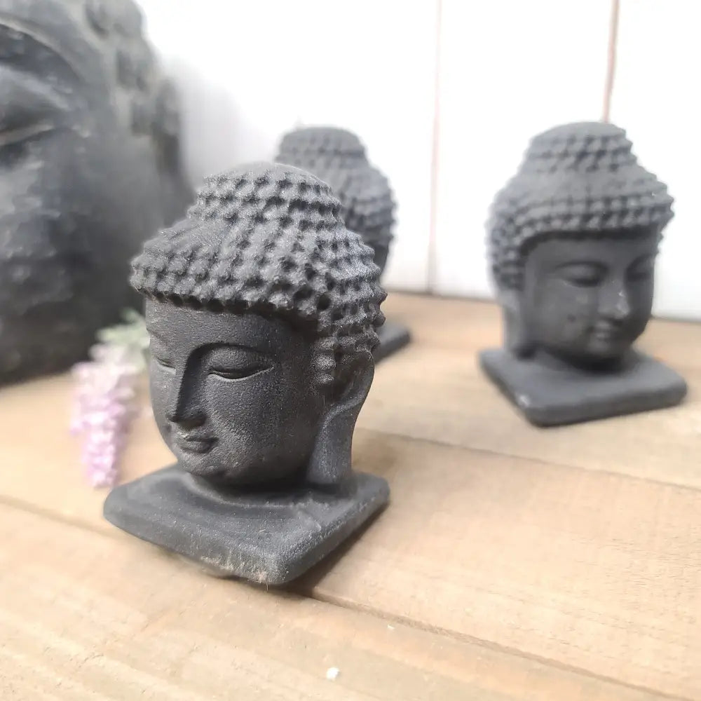 Hand-carved 2.5-inch Black Obsidian Buddha figurine with great detail, featuring serene facial features and intricate patterns, displayed on a white background.