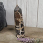 Hand-polished Black Septarian stone featuring bold yellow, brown, and black patterns, displayed on a white background.