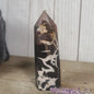 Hand-polished Black Septarian stone featuring bold yellow, brown, and black patterns, displayed on a white background.