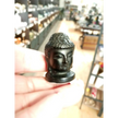 Hand-carved 1 1/2 inch tall Buddha head figurines in assorted crystal materials such as amethyst, rose quartz, clear quartz, and jade, displayed on a white background.