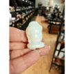 Hand-carved 1 1/2 inch tall Buddha head figurines in assorted crystal materials such as amethyst, rose quartz, clear quartz, and jade, displayed on a white background.