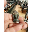 Hand-carved 1 1/2 inch tall Buddha head figurines in assorted crystal materials such as amethyst, rose quartz, clear quartz, and jade, displayed on a white background.