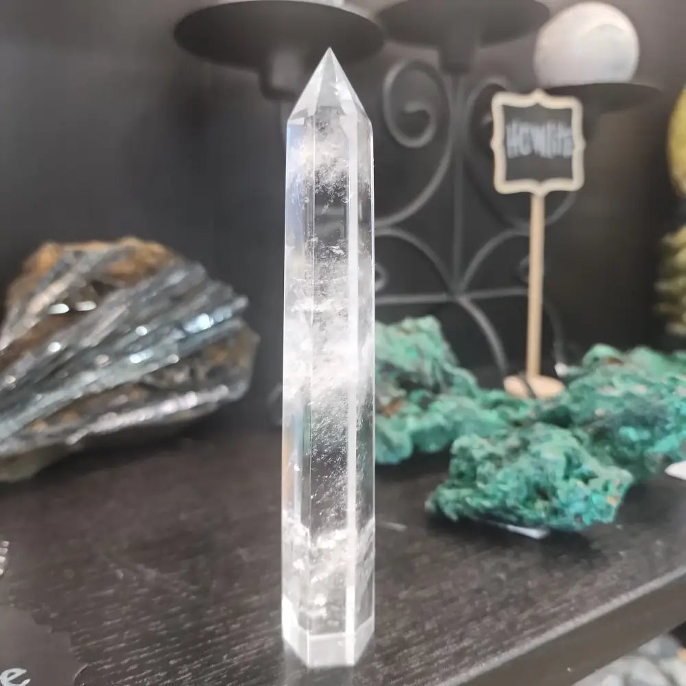 Hand-carved Clear Quartz tower featuring brilliant transparency and natural inclusions, displayed on a white background.