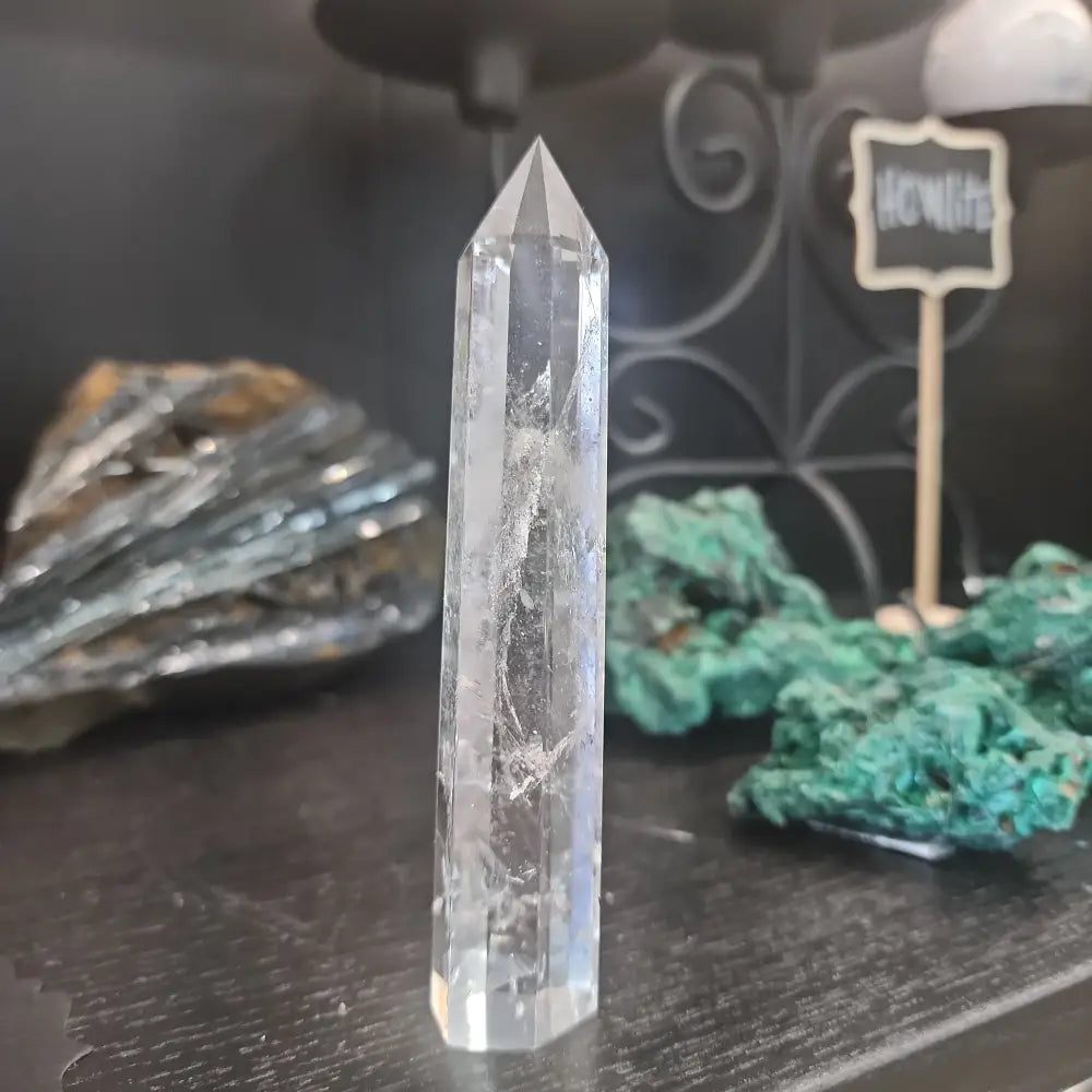 Hand-carved Clear Quartz tower featuring brilliant transparency and natural inclusions, displayed on a white background.