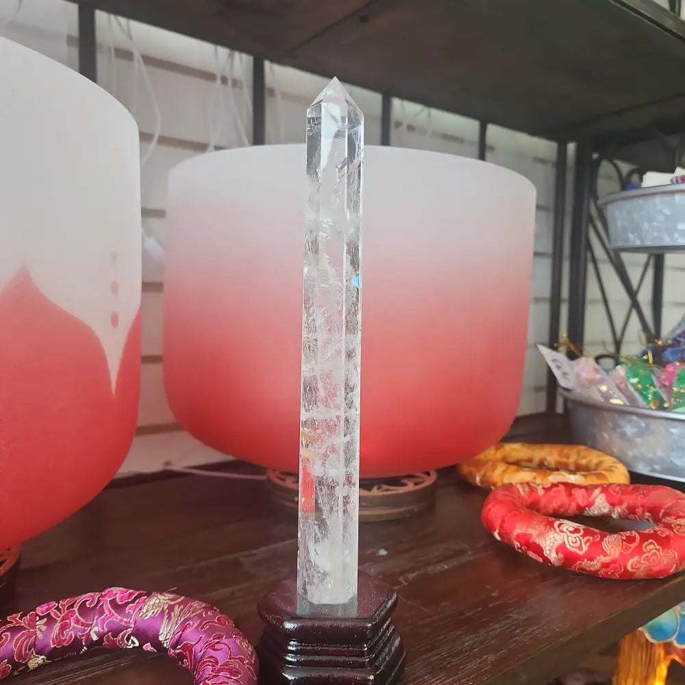 Hand-carved Clear Quartz tower featuring brilliant transparency and natural inclusions, displayed on a white background.