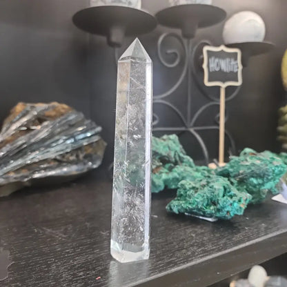 Hand-carved Clear Quartz tower featuring brilliant transparency and natural inclusions, displayed on a white background.