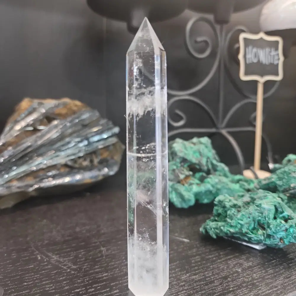 Hand-carved Clear Quartz tower featuring brilliant transparency and natural inclusions, displayed on a white background.