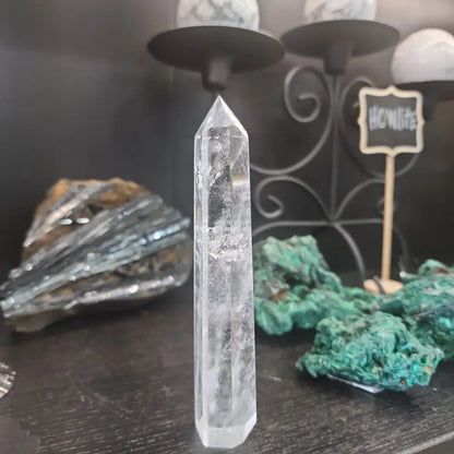 Hand-carved Clear Quartz tower featuring brilliant transparency and natural inclusions, displayed on a white background.