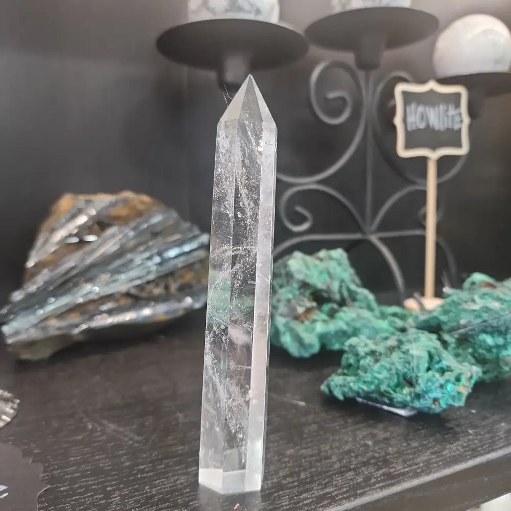 Hand-carved Clear Quartz tower featuring brilliant transparency and natural inclusions, displayed on a white background.