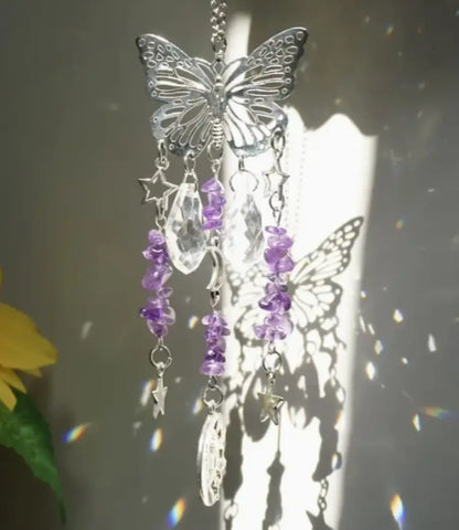 Butterfly-shaped ornament with purple beads and stars on a blurred background