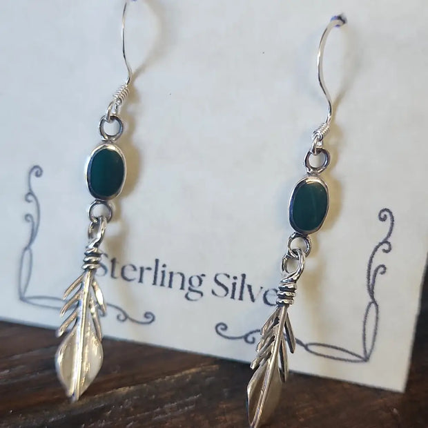 Sterling silver feather earrings featuring vibrant malachite stones, displayed on a white background. Perfect for transformation, protection, and spiritual freedom.