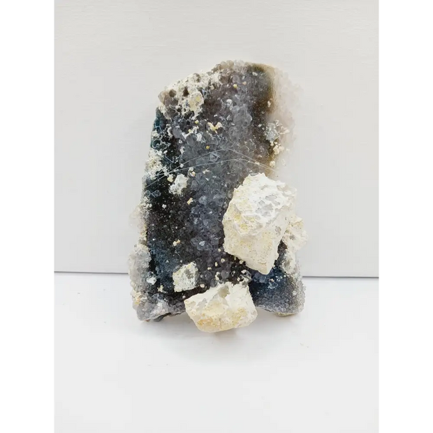 Fine glittery amethyst specimen, featuring sparkling purple points and a shimmering surface, displayed on a white background.