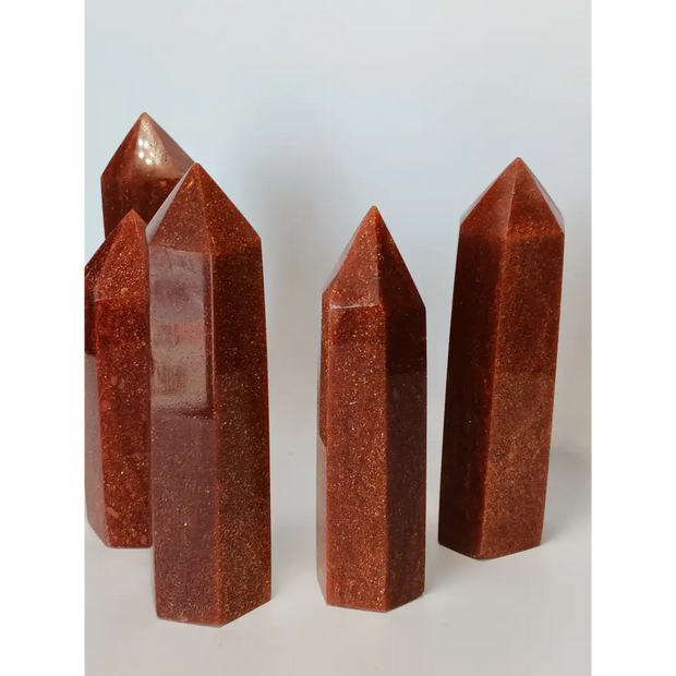 Hand-carved Goldstone tower featuring glittering copper sparkles and a glossy golden-brown finish, displayed on a white background.