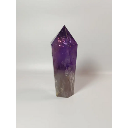 Polished freestanding Amethyst wand with deep purple hues and natural clarity, displayed on a white background.
