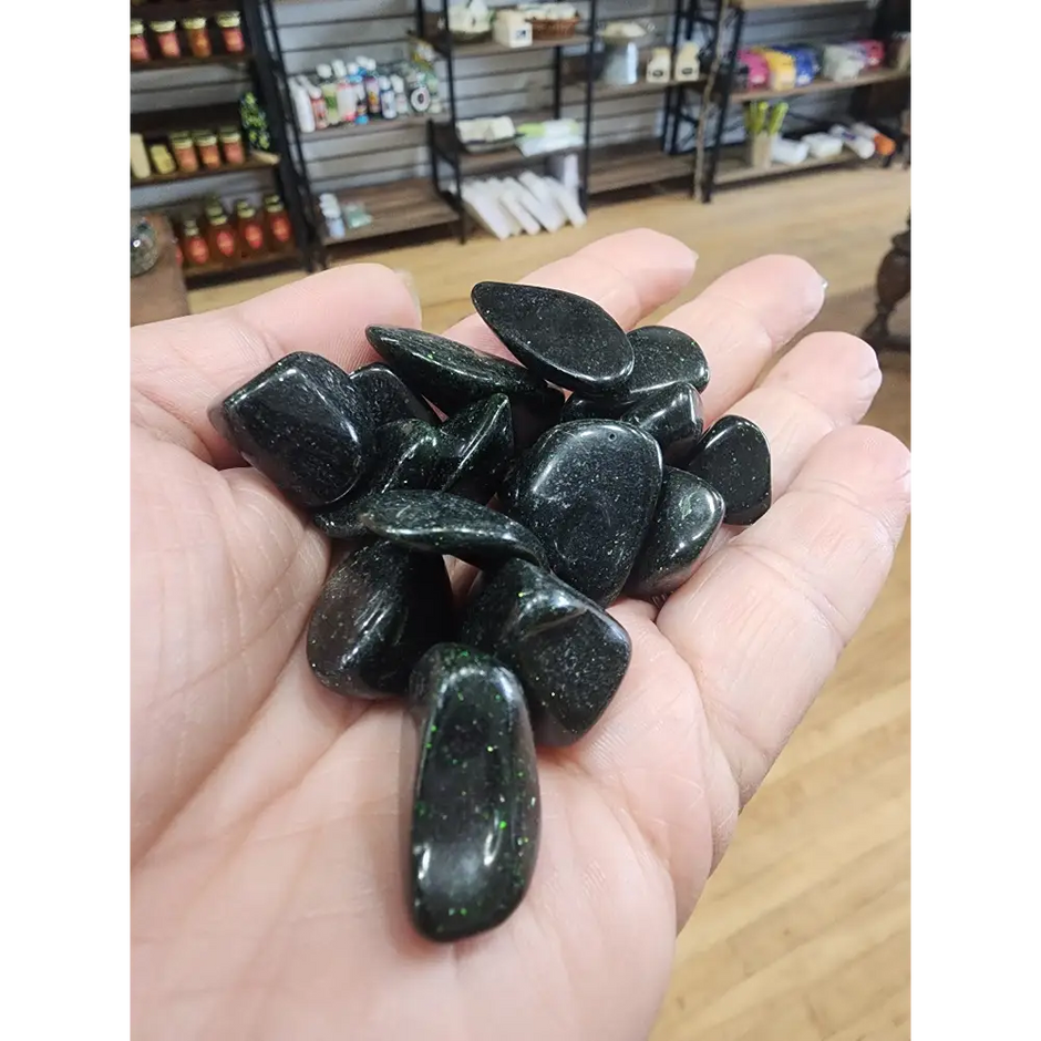 Polished green goldstone tumble with a sparkling, glittery surface, displayed on a white background. Perfect for ambition, abundance, and heart chakra energy.