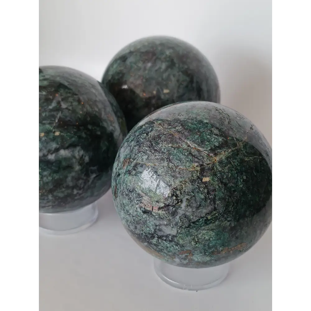 Hand-polished Green Mica sphere featuring sparkling, leafy-green hues and a glossy finish, displayed on a white background.