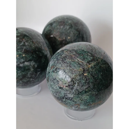 Hand-polished Green Mica sphere featuring sparkling, leafy-green hues and a glossy finish, displayed on a white background.