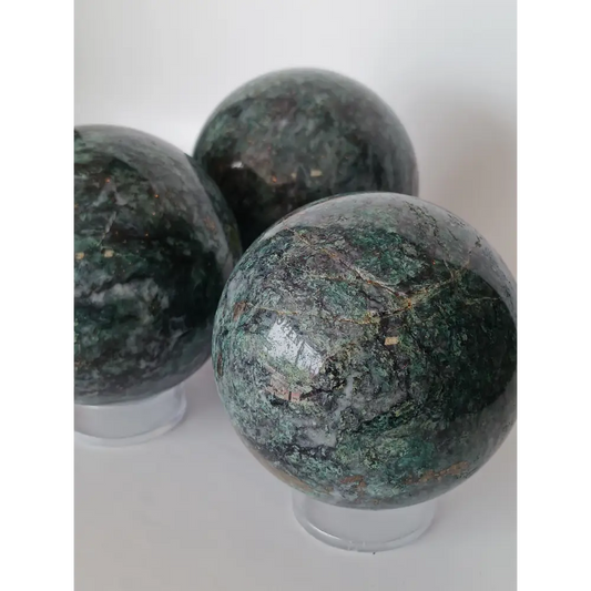 Hand-polished Green Mica sphere featuring sparkling, leafy-green hues and a glossy finish, displayed on a white background.