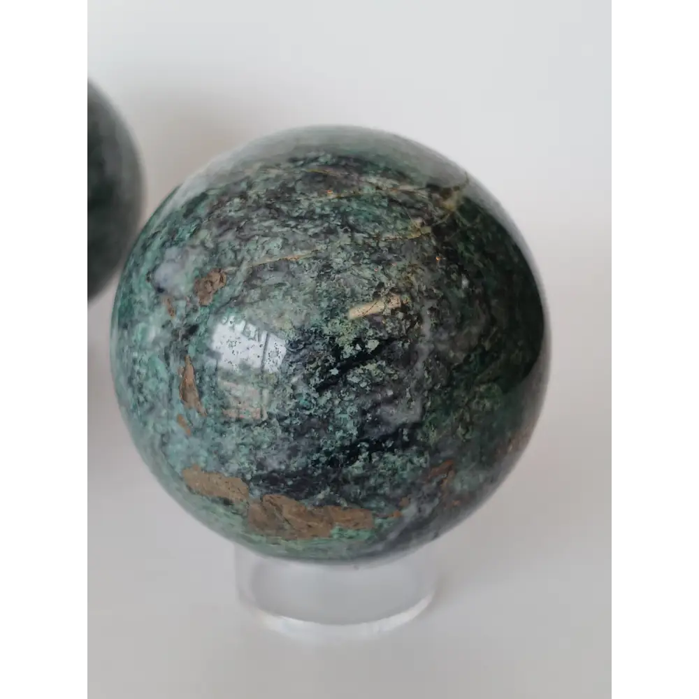 Hand-polished Green Mica sphere featuring sparkling, leafy-green hues and a glossy finish, displayed on a white background.