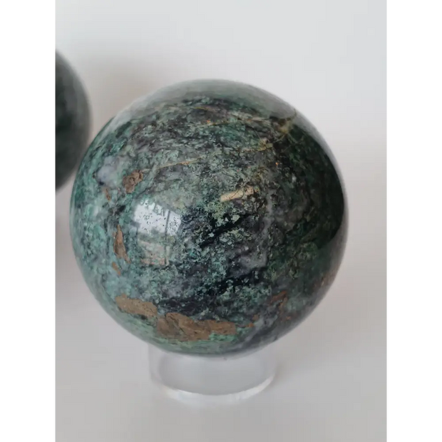 Hand-polished Green Mica sphere featuring sparkling, leafy-green hues and a glossy finish, displayed on a white background.