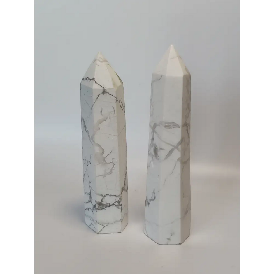 Hand-carved Howlite point featuring soft white coloring with graceful gray veining, displayed on a white background.