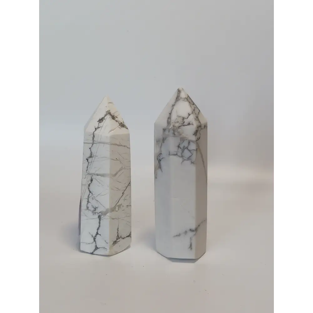 Hand-carved Howlite point featuring soft white coloring with graceful gray veining, displayed on a white background.