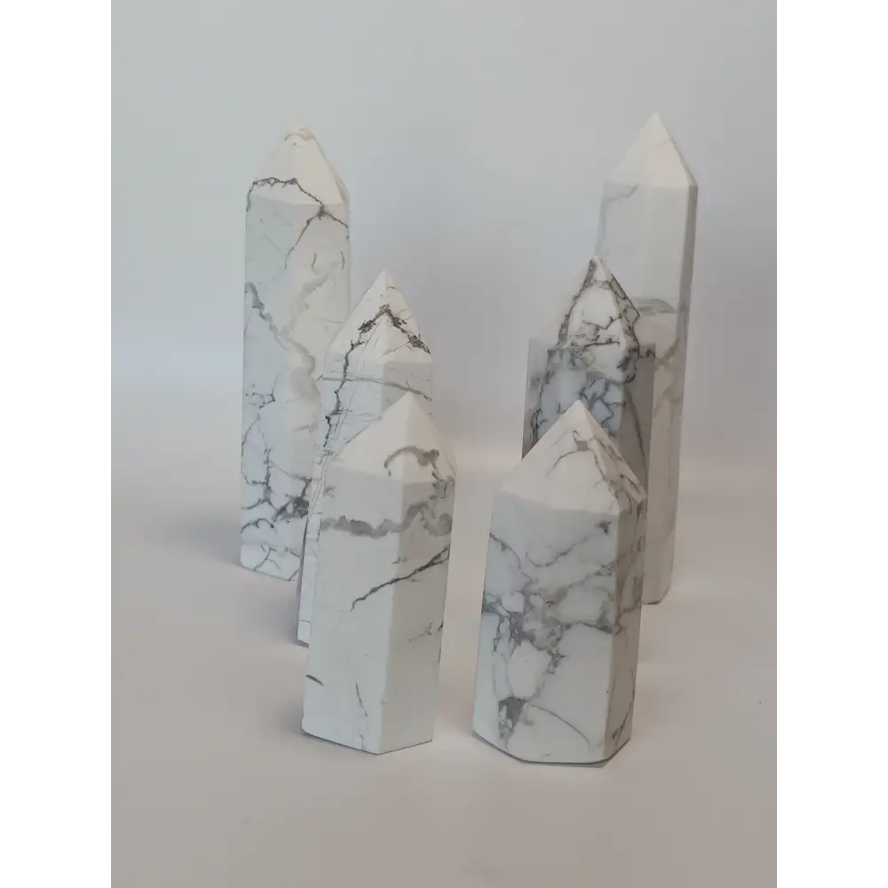 Hand-carved Howlite point featuring soft white coloring with graceful gray veining, displayed on a white background.