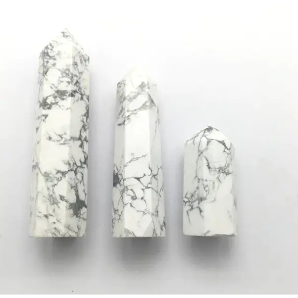 Hand-carved Howlite point featuring soft white coloring with graceful gray veining, displayed on a white background.