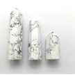 Hand-carved Howlite point featuring soft white coloring with graceful gray veining, displayed on a white background.