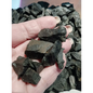 Raw Hypersthene chips with silvery-black flashes, displayed on a white background.