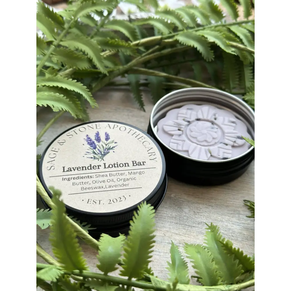 Lavender Lotion Bar in a round shape, surrounded by sprigs of fresh lavender and natural butters, displayed on a white background. Perfect for nourishing, soothing, and hydrating skin.
