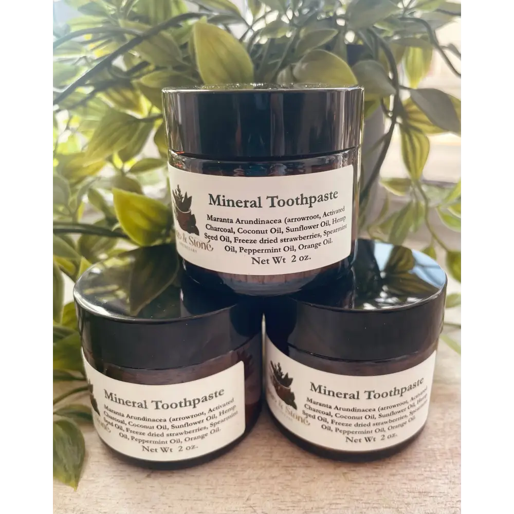 Mineral Toothpaste powder in a small jar, with a bamboo toothbrush beside it, displayed on a white background. Perfect for gently polishing and whitening teeth with natural minerals.