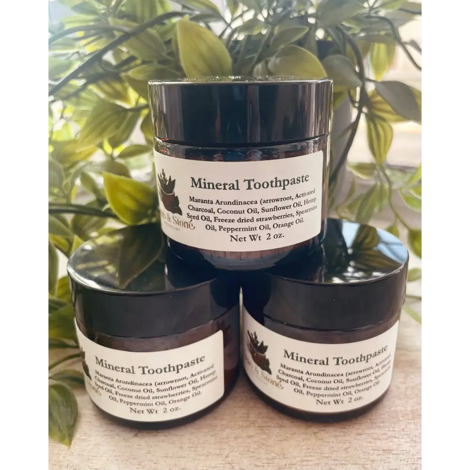 Mineral Toothpaste powder in a small jar, with a bamboo toothbrush beside it, displayed on a white background. Perfect for gently polishing and whitening teeth with natural minerals.