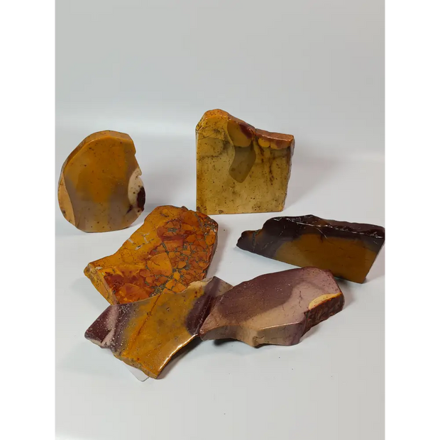 Hand-polished Mookaite slab, 2–2.5 inches, with vibrant red, yellow, and cream patterns, displayed on a white background.