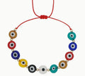 Necklace with colorful evil eye beads on a red cord against a white background