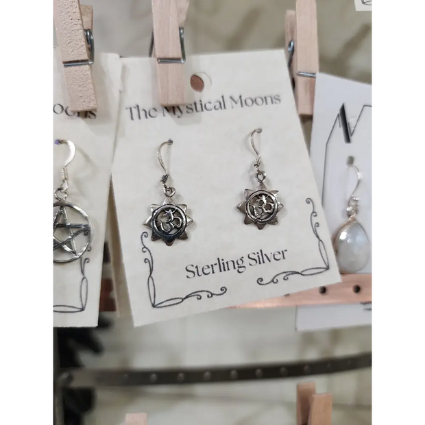 Sterling silver earrings featuring a radiant sun with the Om symbol at the center, displayed on a white background. Perfect for spiritual radiance, peace, and sacred style.