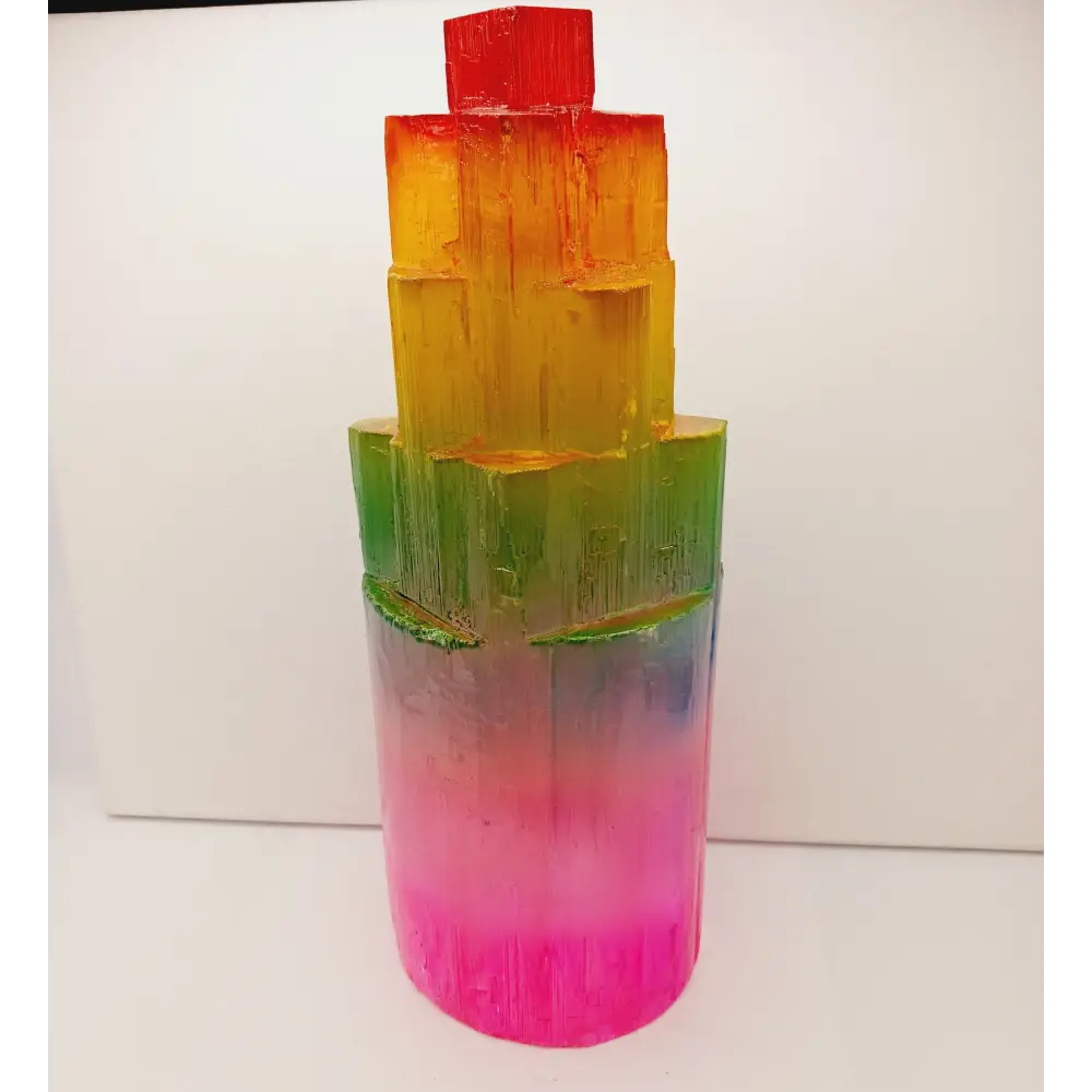Rainbow selenite tiered tower, polished with a vibrant rainbow sheen and step-like design, displayed on a white background.