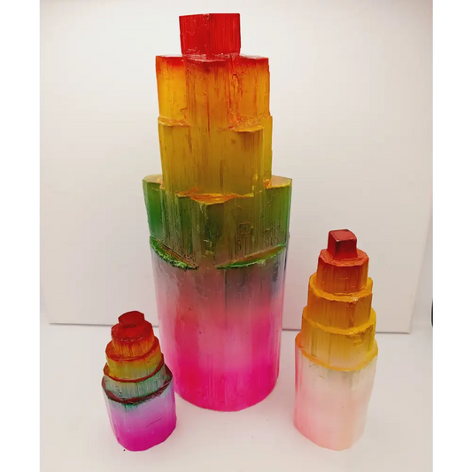 Rainbow selenite tiered tower, polished with a vibrant rainbow sheen and step-like design, displayed on a white background.