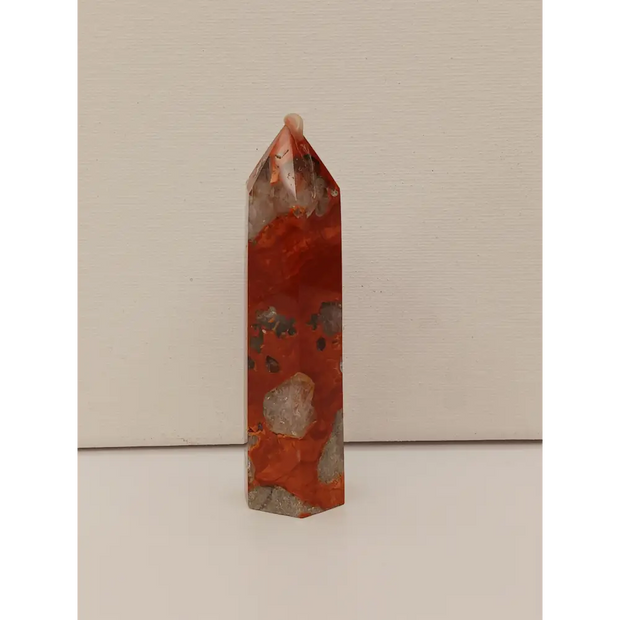 Hand-carved Red Jasper point with a clear quartz band, featuring vibrant red tones and a striking clear quartz stripe, displayed on a white background.