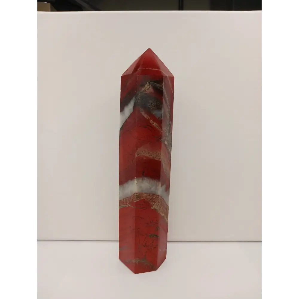 Hand-carved Red Jasper point with a clear quartz band, featuring vibrant red tones and a striking clear quartz stripe, displayed on a white background.
