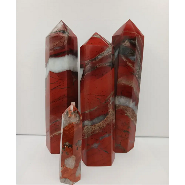 Hand-carved Red Jasper point with a clear quartz band, featuring vibrant red tones and a striking clear quartz stripe, displayed on a white background.